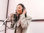 Stock photo of voice talent in a recording booth.