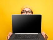 Expressive young man in glasses giving innovative laptop.