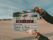 Arms holding a clapperboard.